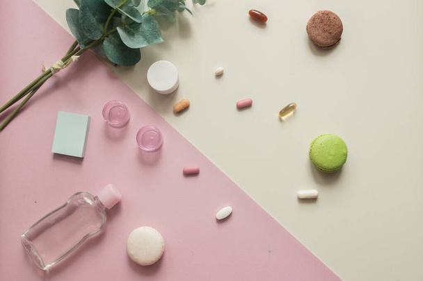 A close-up top view of various pills and macaronis on pink and yellow background. Dietary supplements and vitamins. Medical, pharmacy and health care concept. Copy place for text or logo. Top view - Foto, Bild