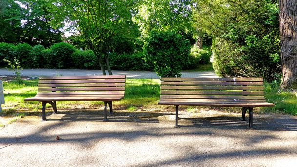 bancos de parque vacíos con sol y sombra
 - Foto, Imagen