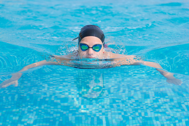 Young girl swimming butterfly stroke style - 写真・画像