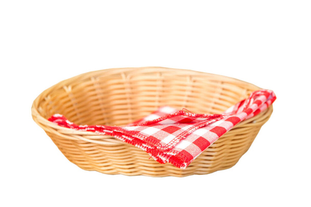 Rieten mand met rode katoenen servet binnenkant geïsoleerd op een witte achtergrond - Foto, afbeelding