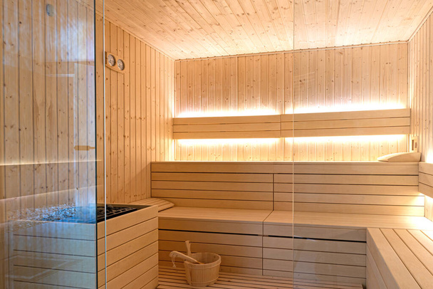 Puste wnętrze tradycyjnej sauny fińskiej. Nowoczesna drewniana kabina terapeutyczna z gorącą suchą parą - Zdjęcie, obraz