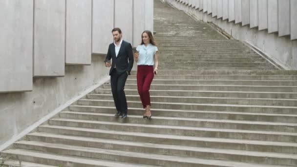 Colegas confiantes a descer escadas. Homem e mulher falando na rua
 - Filmagem, Vídeo