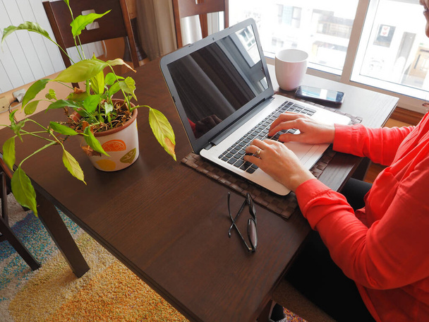 Жінка працює з дому з ноутбуком, мобільним телефоном
. - Фото, зображення