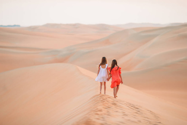 Birleşik Arap Emirlikleri 'nde Rub al-Khali çölündeki kum tepeleri arasında yaşayan kızlar - Fotoğraf, Görsel