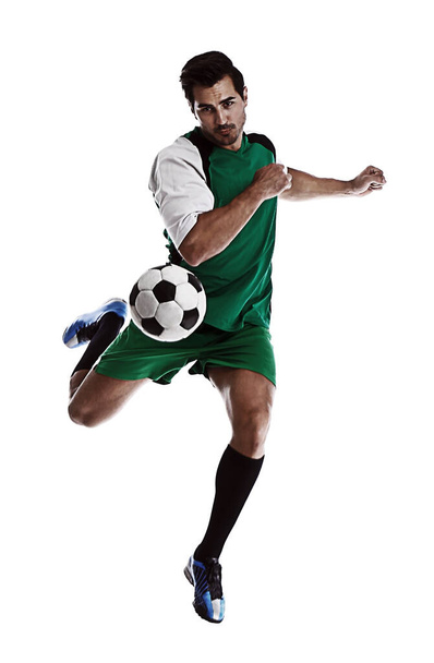 Young man playing football on white background - Foto, afbeelding