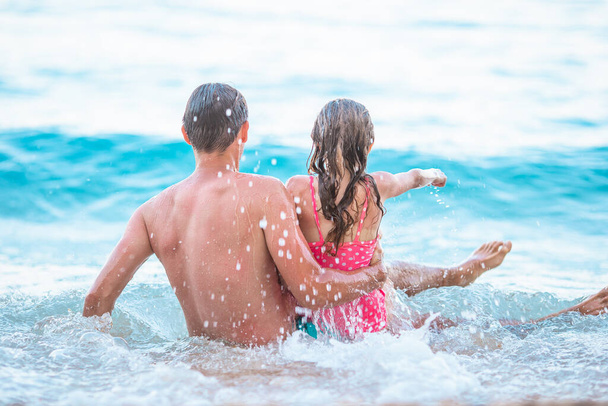 Father and his daughter enjoy beach vacation - Фото, зображення