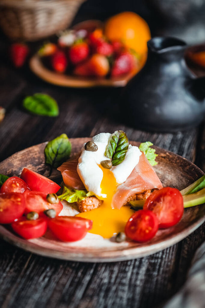 poached egg with avocado and vegetables with salmon and herbs in bowl on brown wooden table, healthy breakfast concept - Photo, image