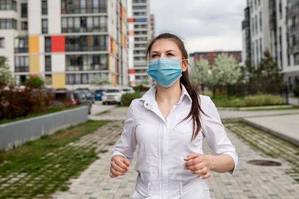 girl in a medical mask on the street. girl in a medical mask in the city. girl 20-29 years old - Fotoğraf, Görsel