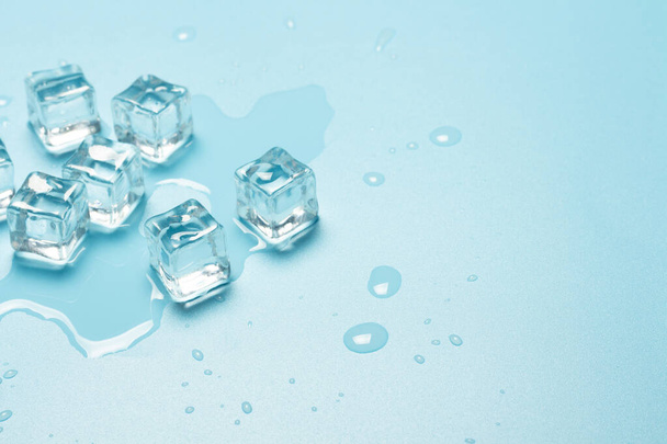 Cubes de glace avec de l'eau sur fond bleu. Concept de glace pour les boissons. Bannière. Couché plat, vue du dessus
. - Photo, image