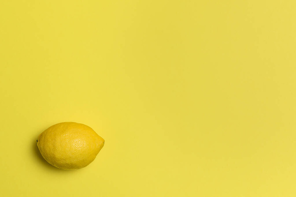 Eine reife Zitrone auf gelbem Hintergrund - Foto, Bild