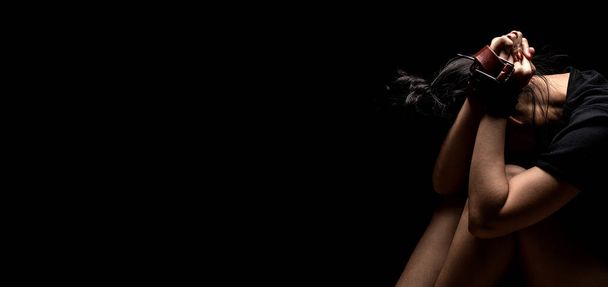 Dia Internacional de Direito Humano Conceito: mulher amarrada com cinto de couro em estresse emocional e dor
 - Foto, Imagem