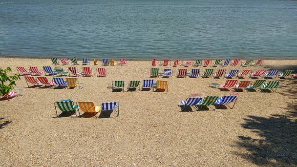 Пляжні стільці на пляжі. Стільці на піщаному гальковому пляжі біля моря. Концепція літнього відпочинку та відпустки для туризму. Натхненний літній пейзаж. Релакс на пляжі
 - Фото, зображення
