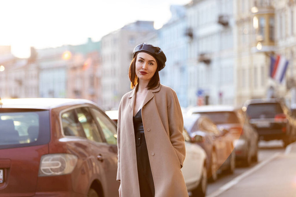 Beautiful woman in black pantsuit walks on promenade in Saint-Petersburg - Photo, Image
