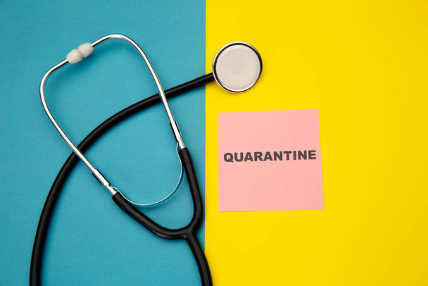 Quarantine - message on pink sticky note near stethoscope. Need for quarantine during illness - Zdjęcie, obraz