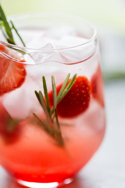 soda with strawberry and rosemary in glass with ice. Concept of refreshment beverage for sunny day - Foto, immagini