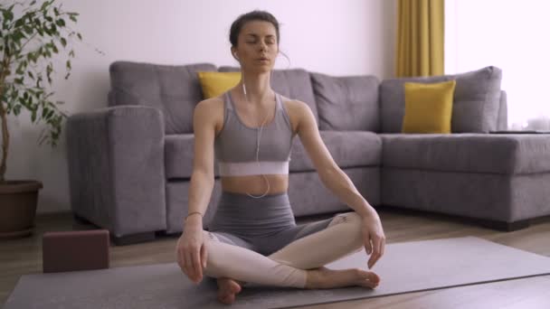 Sporty girl meditating at home during self isolation - Felvétel, videó