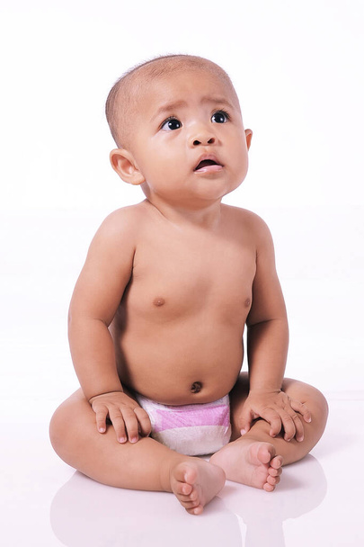 Portret van schattige peuter Een Aziatisch baby meisje dragen luier en zitten naakt, geïsoleerd op wit - Foto, afbeelding