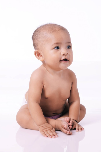 Şirin Bebek 'in portresi. Bebek bezi takan Asyalı bir kız çocuğu. Çıplak oturuyor, beyaz tenli. - Fotoğraf, Görsel