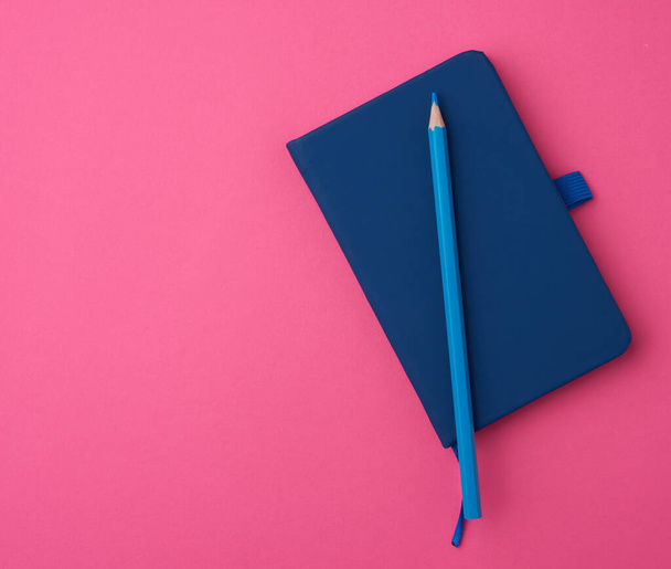 blue notebook on a pink background, backdrop for the designer - Foto, afbeelding
