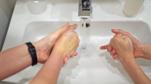 Familie wäscht sich zu Hause die Hände unter dem Wasserhahn. Coronavirus-Schutzkonzept. - Filmmaterial, Video