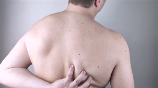 Vállfájás. Egy férfi egy orvosi vizsgálaton egy csigolyánál, aki fájdalomra panaszkodik az interscapularis régióban és a hátán.. - Felvétel, videó