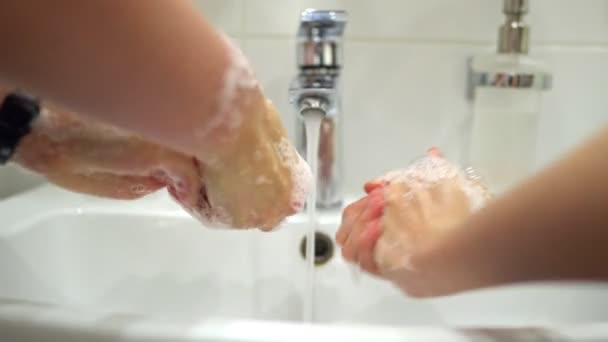 Família lavar as mãos sob torneira de água em casa. Conceito de proteção contra o coronavírus
. - Filmagem, Vídeo