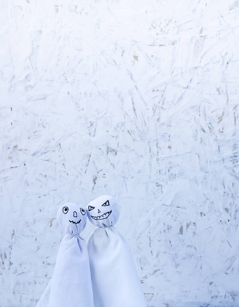 Díszítés Halloweenre. Két szellem figura, világos háttérrel. Kézzel készített dekoráció partikhoz. - Fotó, kép