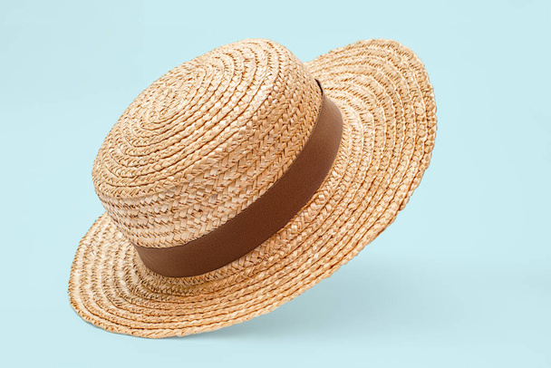 Boater straw hat flying isolated in studio. Concept of fashion clothing accessories and beach holidays - Фото, зображення