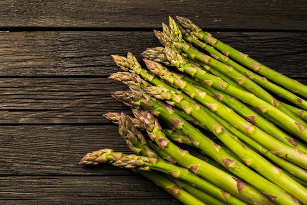 Bunch of fresh asparagus on wooden table - 写真・画像