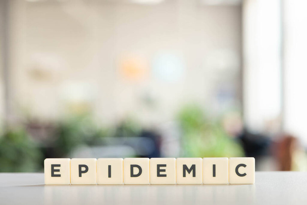white cubes with epidemic lettering on white desk, covid-19 concept - Photo, Image