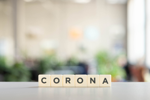 white cubes with corona lettering on white surface, covid-19 concept - Фото, изображение