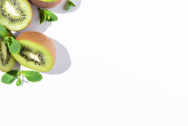 top view of ripe kiwi fruit halves near peppermint on white  - Photo, Image