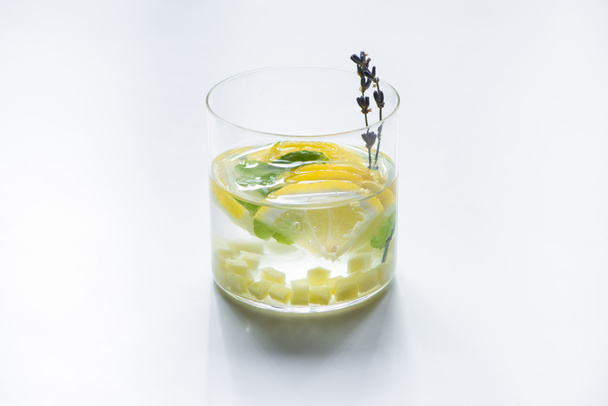 verse gember limonade in glas met munt en lavendel tak op witte achtergrond - Foto, afbeelding