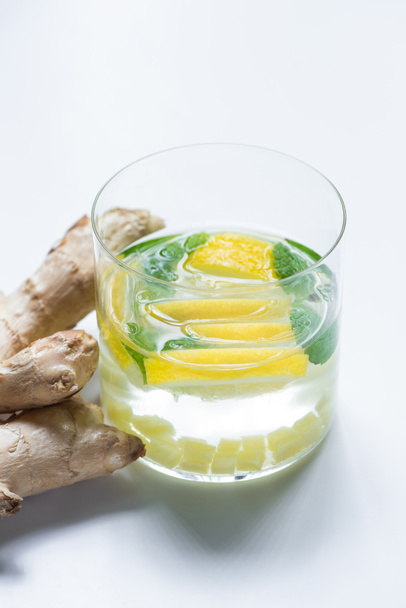 fresh lemonade in glass with lemon near ginger root on white background - Photo, Image
