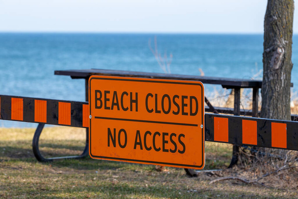 ビーチは、バックグラウンドで砂と青い水にアクセスできないサインを閉じました - 写真・画像
