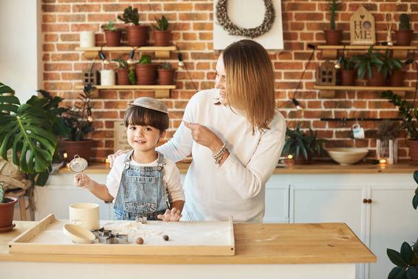 young beautiful family having fun and cooking in the sunny kitchen - Фото, зображення