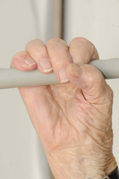 Paliativní péče o osoby s chronickým onemocněním, ruka držící rukojeti v nemocničním lůžku - Fotografie, Obrázek