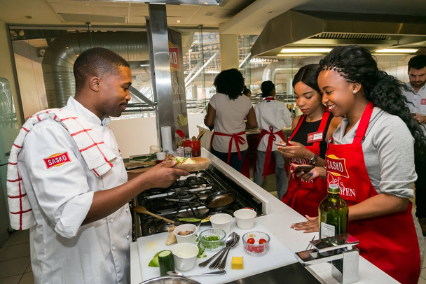 Johannesburg, South Africa - November 10, 2016: Diverse young people learning to cook and bake at a cooking class - Photo, image