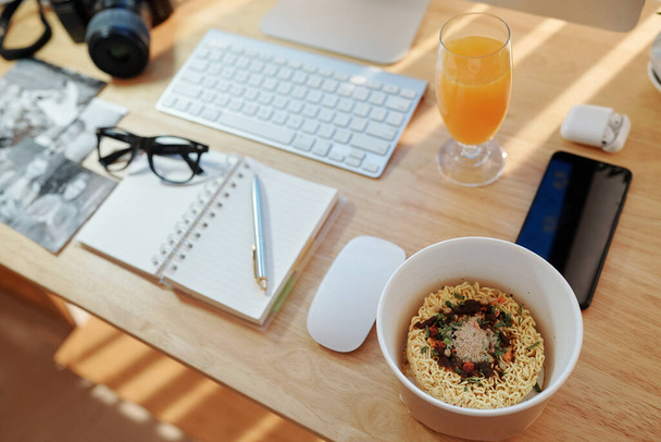 Bowl with instant noodles and species on desk of business person working from home during quarantine - Photo, Image