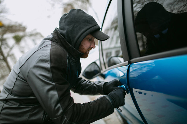 Zloděj aut kradoucí auto v autě zloděj doorglove porušuje zákon, hackne zámek na autě, aby se dostal dovnitř - Fotografie, Obrázek