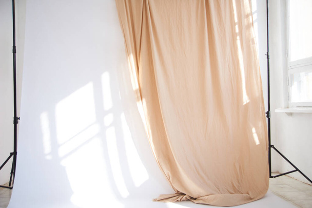 Ciclorama bianco in fotostudio. sfondo in tessuto su ciclorama in uno studio fotografico con luce solare naturale dalla finestra. luce naturale proveniente da grandi finestre
 - Foto, immagini