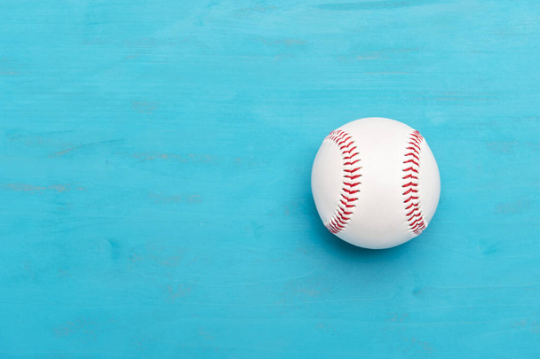 Бейсбольний м'яч на синьому дерев'яному фоні. Концепція командного спорту
 - Фото, зображення