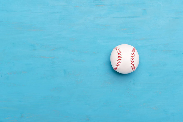 Бейсбольный мяч на синем деревянном фоне. Командный спорт
 - Фото, изображение
