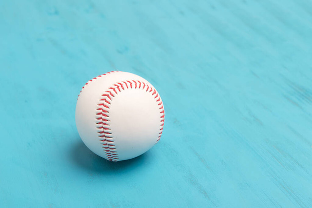 Baseball na niebieskim drewnianym tle. Koncepcja sportowa - Zdjęcie, obraz
