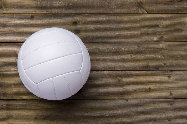 Білий волейбольний м'яч на старій дерев'яній підлозі
 - Фото, зображення