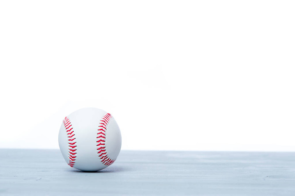 Close up of baseball ball on grey wooden floor. Online workout concept - Photo, Image