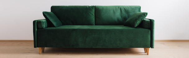 μοντέρνο πράσινο καναπέ με μαξιλάρια στο δωμάτιο, πανοραμική λήψη - Φωτογραφία, εικόνα