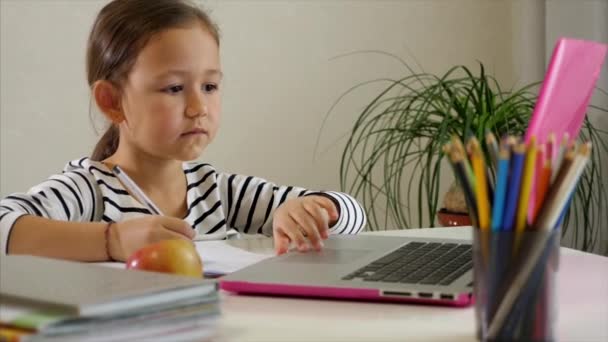 Little child girl is studying online at home - Footage, Video