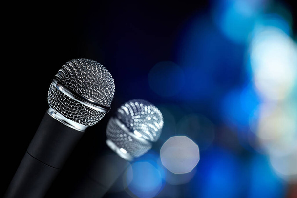 Nahaufnahme zweier moderner Mikrofone mit silbernem Mesh auf abstraktem Hintergrund. - Foto, Bild