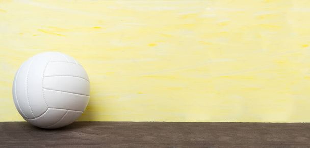 Білий волейбольний м'яч ізольований на жовтому тлі. Концепція командного спорту
 - Фото, зображення